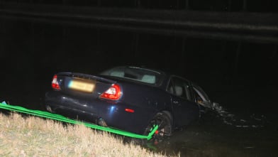 Jaguar belandt in Havenkanaal Wilhelminadorp