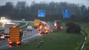 Vrachtauto in berm naast snelweg, flinke file op A58