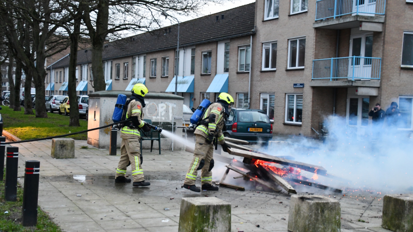 Een stapel balken stond op een pleintje in brand.