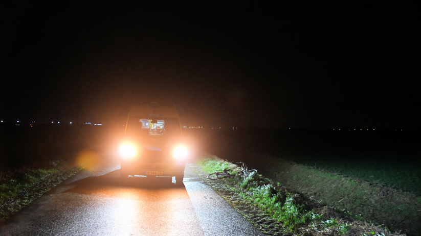 De fietser lag in de kletsnatte berm.